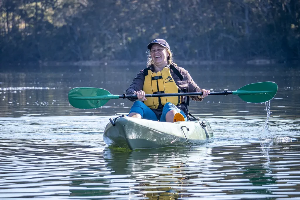Female paddler enjoying a guided kayak trip on Corunna Lake.